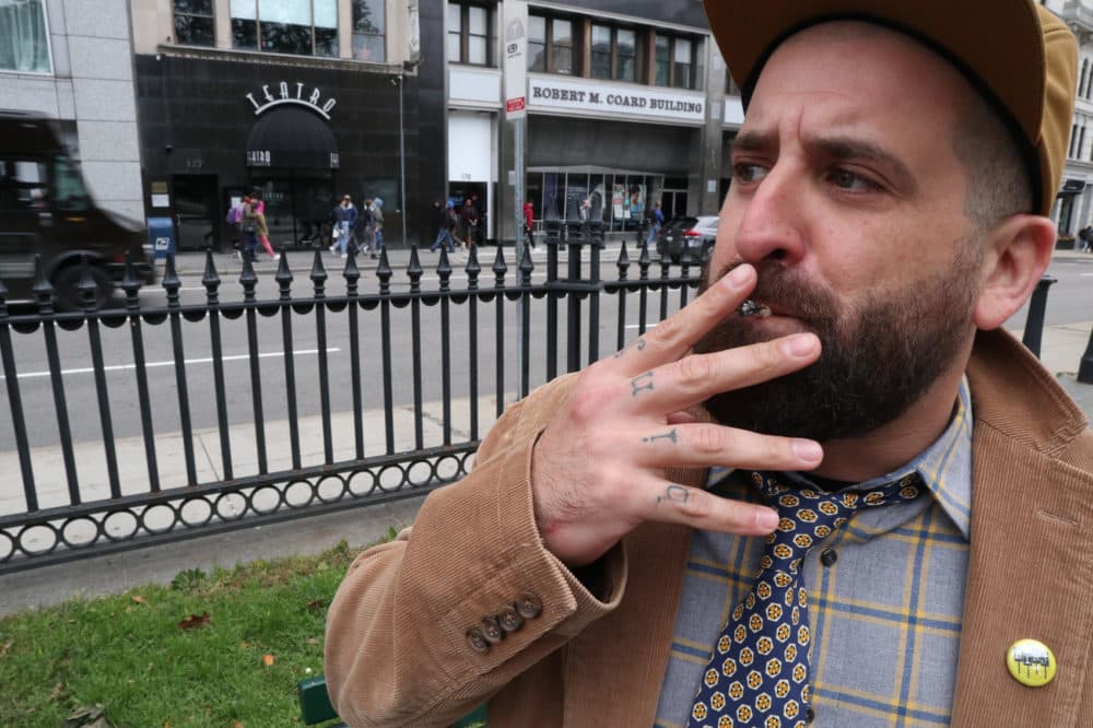 Tattooed on Chris Faraone's fingers are the letters B-I-N-J, which stand for Boston Institute for Nonprofit Journalism. (Adrian Ma/WBUR)