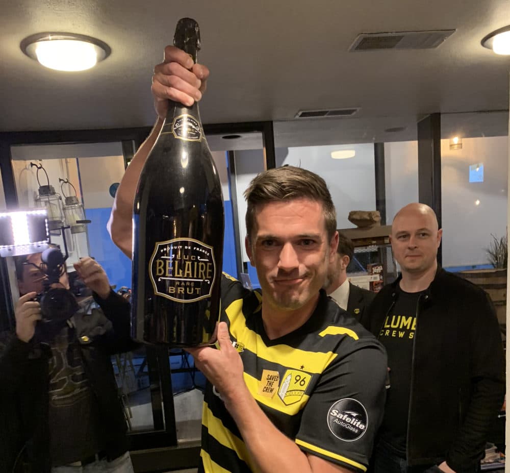 Morgan Hughes poses with a bottle of champagne after the Crew had been saved. (Courtesy Save the Crew)