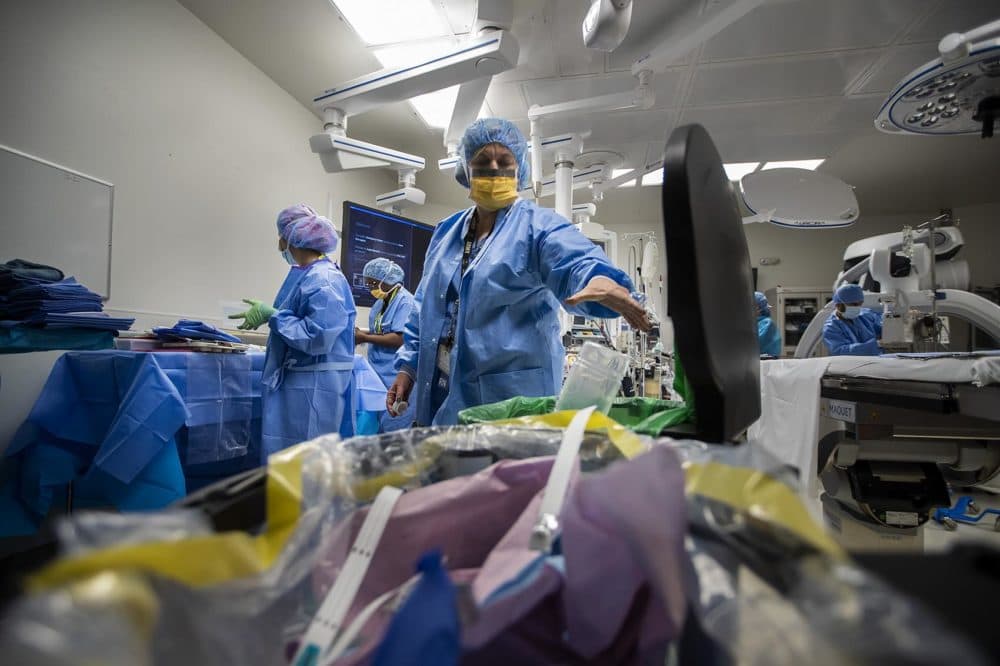 Janine Hardman recycles a plastic bottle while prepping for the next procedure in the operating room. (Jesse Costa/WBUR)