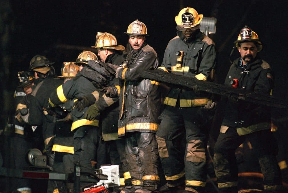 A row of firefighters form a line to remove debris from the fire-gutted Worcester Cold Storage building in the search for the missing firefighters Tuesday, Dec. 7, 1999. (AP photo courtesy Worcester Telegram & Gazette)