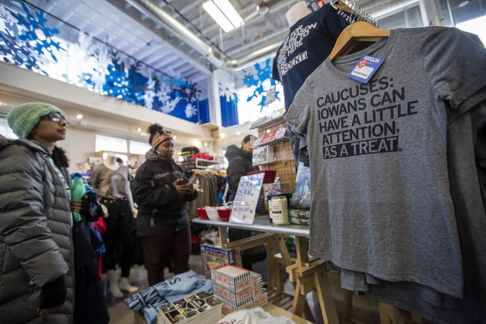 Shoppers at RAYGUN in Des Moines peruse the selection of printed T-shirts and other items with various quips about the Iowa caucus. (Jesse Costa/WBUR)