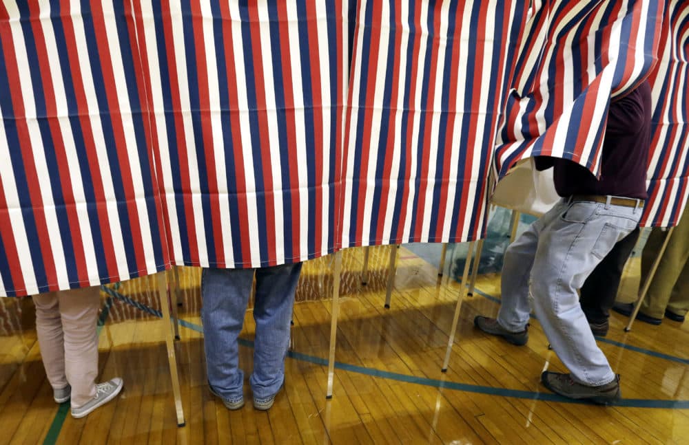 In this Nov. 8, 2016 file photo, a voter enters a booth at a polling place in Exeter, N.H. (Elise Amendola/AP Photo)