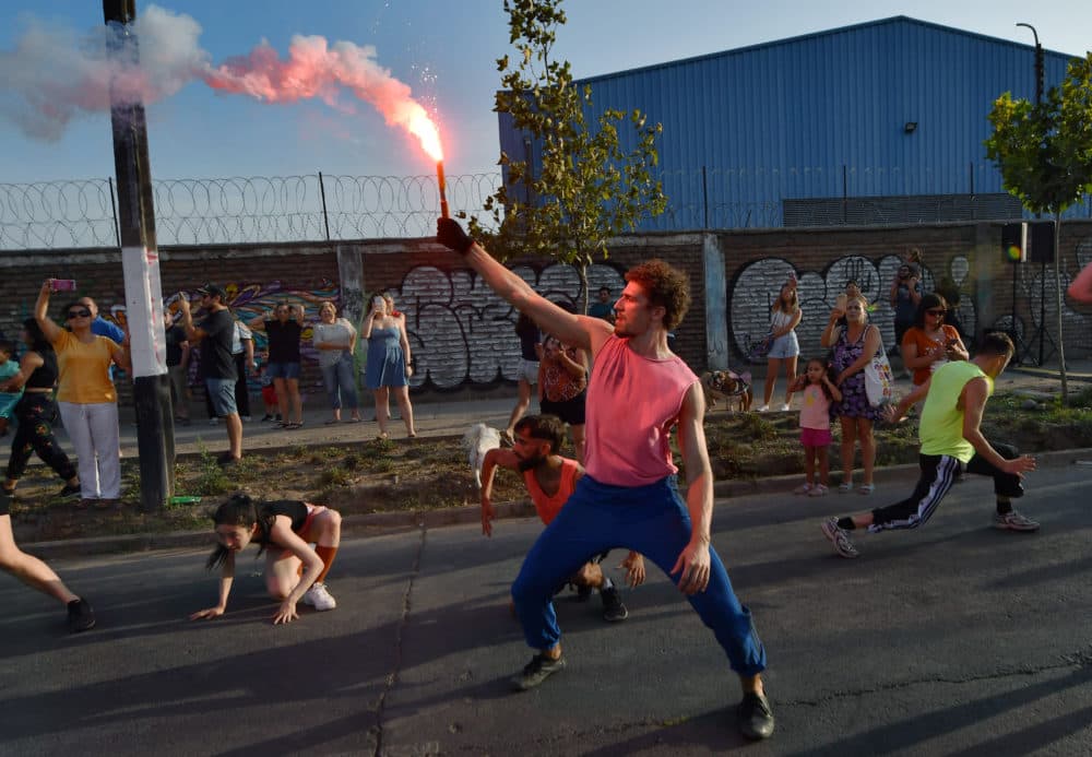 A dancer raises a flare during a performance of José Vidal's "Emerger." (Jorge Sanchez for WBUR)