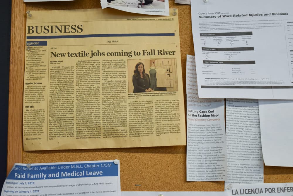 en avis klipning om åbningen af godt tøj selskab hænger på væggen på Fall River factory. (Allison Hagan / her nu)