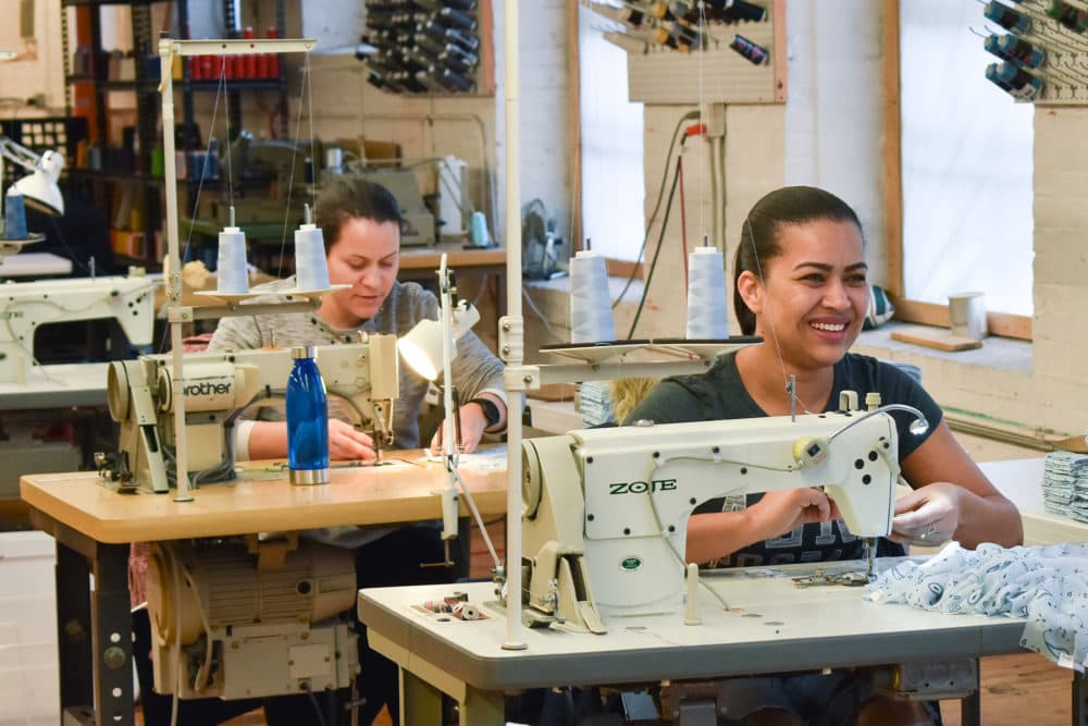 švadlena pracující průmyslové šicí stroje v Good Clothing Company ve Fall River, Massachusetts. (Allison Hagan/zde)