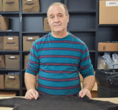 Som fabrikken kutter, Tony Arruda fortsatt bruker hendene til å kutte store ruller av stoff ned til størrelse. (Allison Hagan/Her Nå)