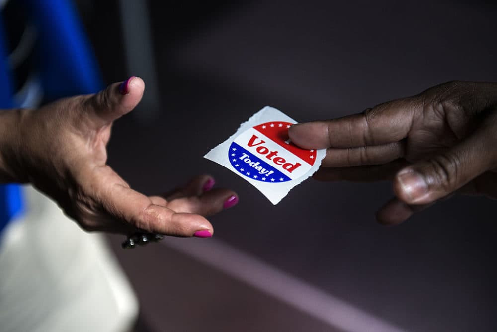 A poll worker hands out "I Voted Today" stickers. (Brendan Smialowski/AFP/Getty Images)
