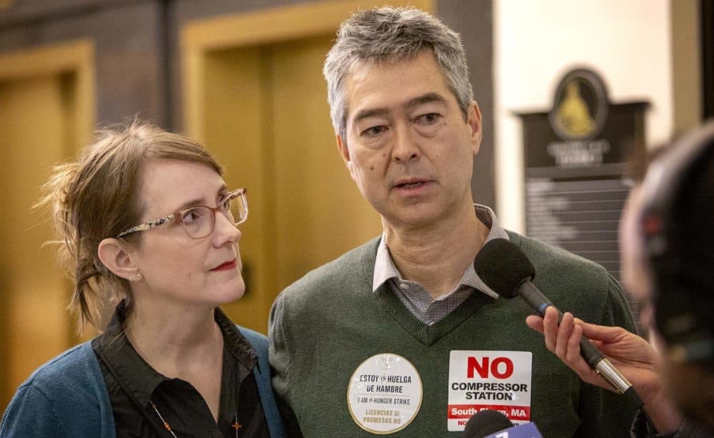 Nathan Phillips, a Boston University earth and environment professor, and activist Andrea Honore speak with reporters at the Massachusetts State House. (Robin Lubbock/WBUR)
