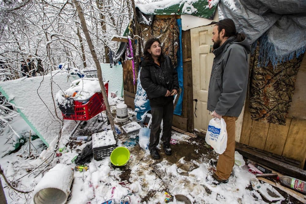 Evis Terpollari, right, checks with Monte Kelly, who was living in a shack in the woods he built using material he pulled from dumpsters. (Jesse Costa/WBUR)