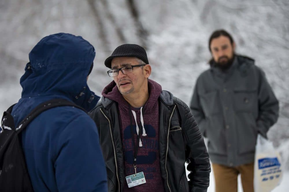 Recovery coach Richard Gonzalez asks Eduardo Vasquez whether he would be willing to stay at a shelter for the night. (Jesse Costa/WBUR)