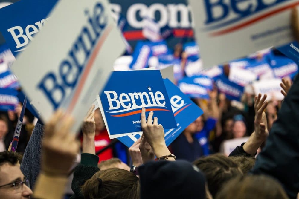 Bernie Sanders supporters wave Bernie signs as positive news that he is leading the pack during the New Hampshire Primary. (Jesse Costa/WBUR)