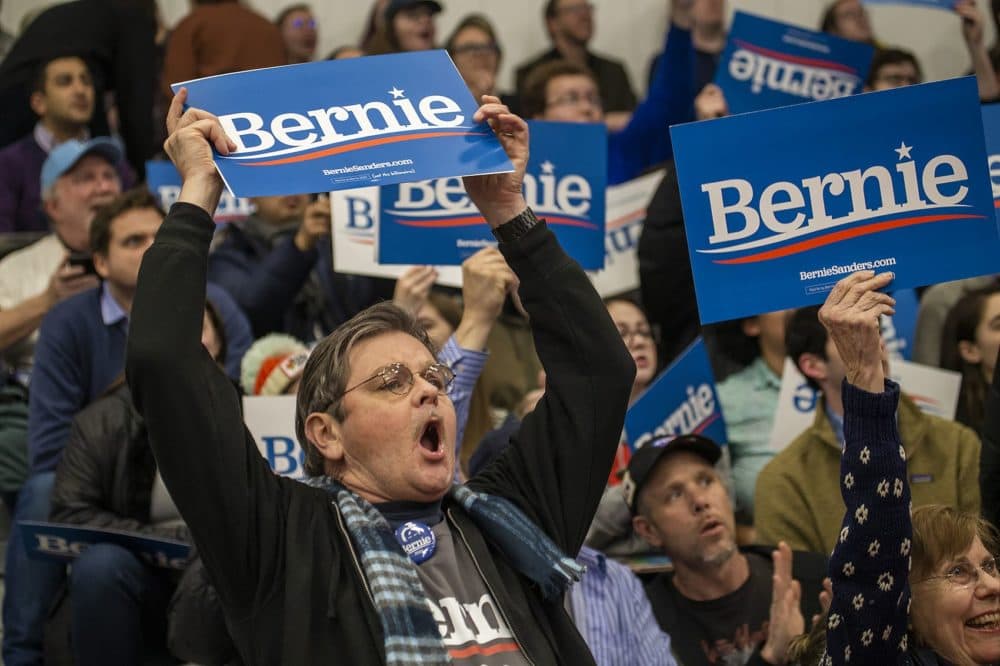 Bernie Sanders supporter William Collins of Harwich, Mass. waves a Bernie sign at the senator's primary night rally. (Jesse Costa/WBUR)