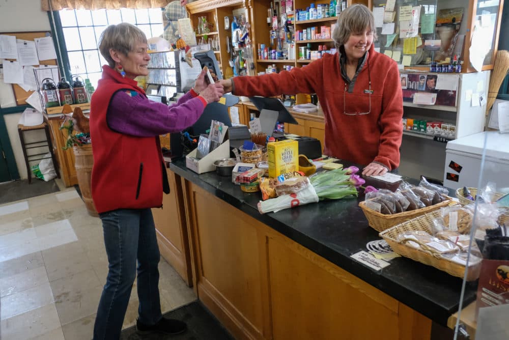 Toni Halla talks with a customer from behind the counter. (Jill Ryan/Here & Now)