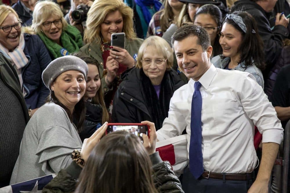 Pete Buttigeig poses with supporters at Elm Street Middle School in Nashua, NH. (Robin Lubbock/WBUR)