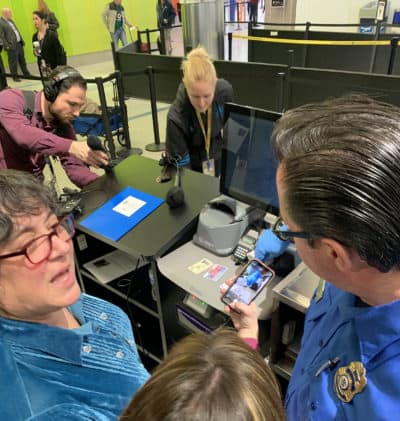 TSA spokeswoman Lisa Farbstein, left, and TSA officer James Freel demonstrate Logan Airport's new credential authentication machines. (Simón Rios/WBUR)