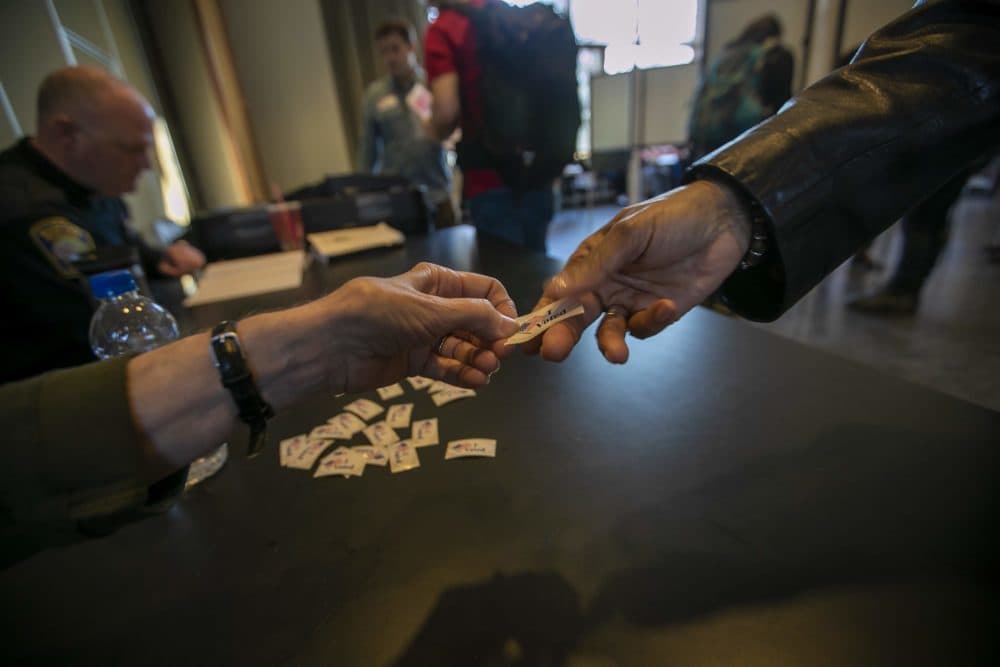 An 'I voted' sticker is handed to a voter at the Allston branch of the Boston Public Library. (Jesse Costa/WBUR)