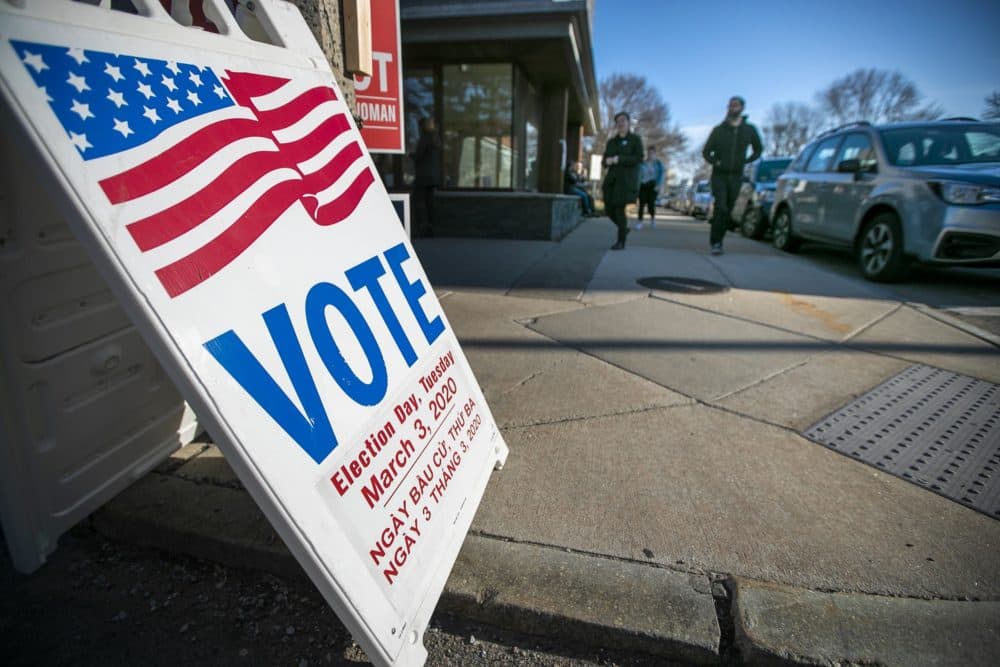 Voters file in and out at the Allston branch of the Boston Public Library. (Jesse Costa/WBUR)