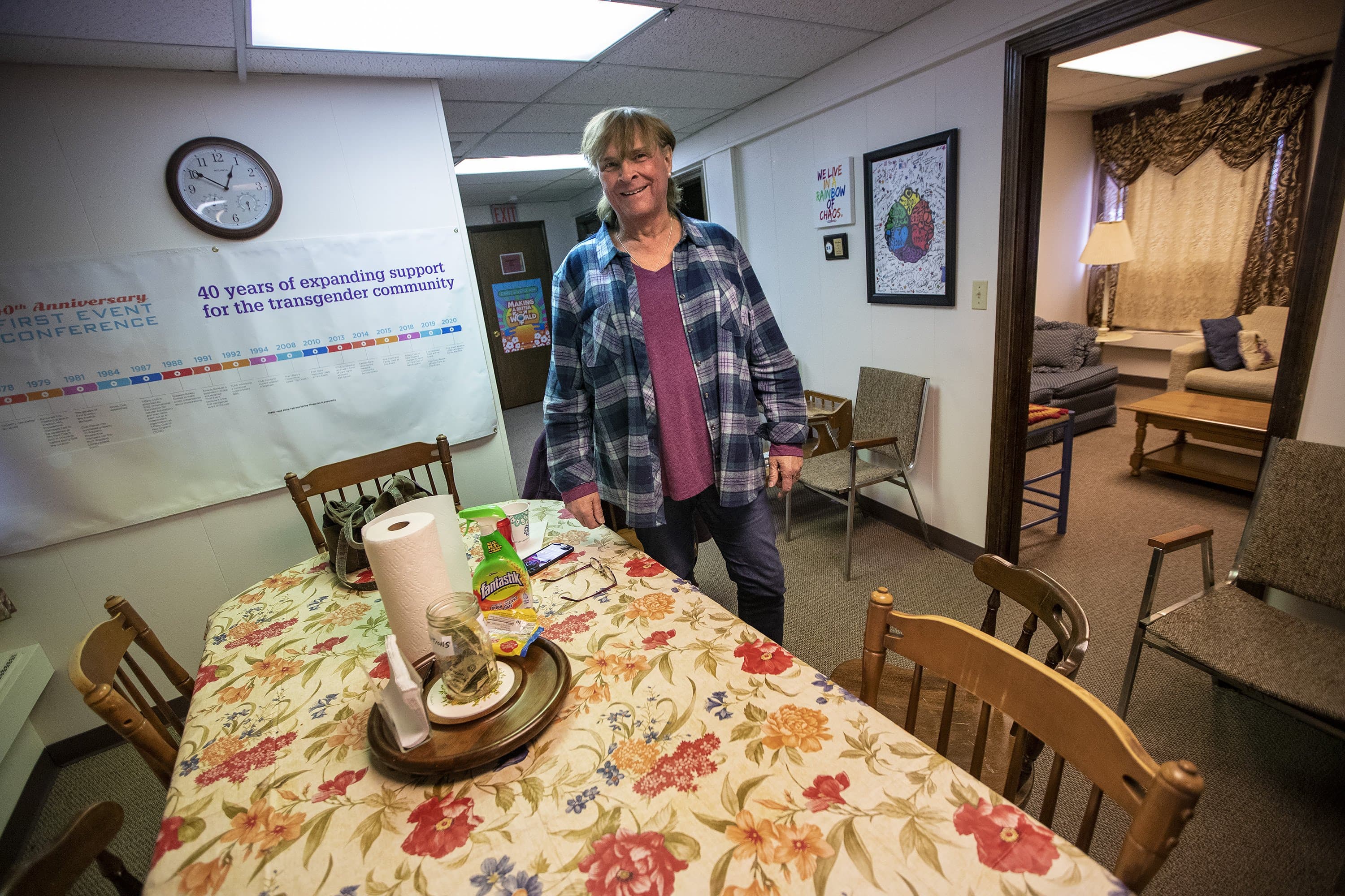 Karen Belmore stands in one of the common spaces at the Trans Club of New England which has been closed in an effort to protect members from the spread of the coronavirus. (Jesse Costa/WBUR)