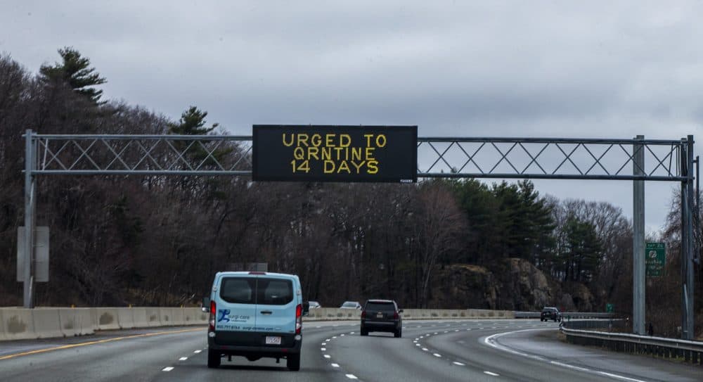 A sign on route 95 in Waltham urging drivers from outside of Massachusetts to do a 14-day quarantine when arriving for their visit. (Jesse Costa/WBUR)