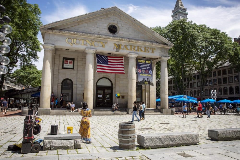 People begin to return to Quincy Market at lunchtime, as the market reopens after being closed to slow the spread of the coronavirus. (Robin Lubbock/WBUR)
