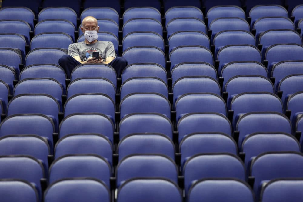 A fan sits in an empty arena after the Atlantic Coast Conference tournament was canceled. (Ben McKeown/AP)