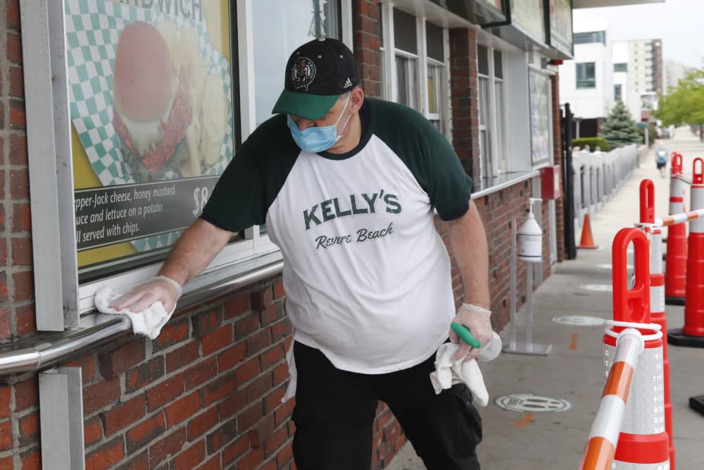 Chris Dotoli wipes down surfaces, June 3, 2020, outside Kelly's Roast Beef in Revere. Kelly's is open for outside delivery of food in accordance with the state's coronavirus guidelines. (Elise Amendola/AP)