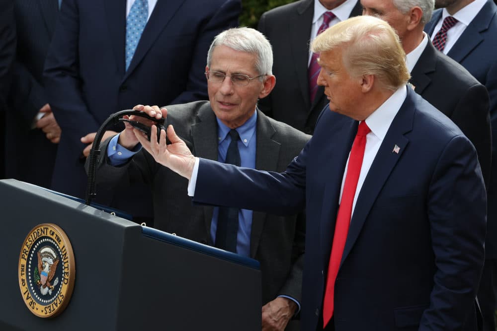 U.S. President Donald Trump adjusts the microphone for National Institute Of Allergy And Infectious Diseases Director Anthony Fauci during a news conference where Trump announced a national emergency in response to the ongoing global coronavirus pandemic in the Rose Garden at the White House March 13, 2020 in Washington, DC. (Chip Somodevilla/Getty Images)
