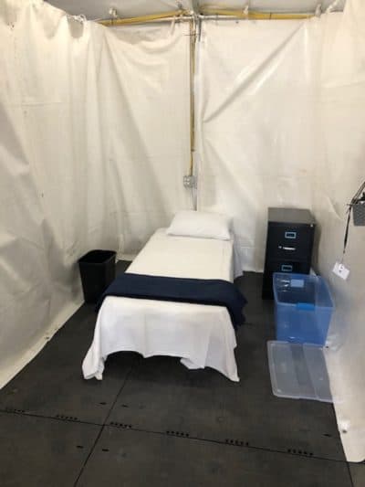 Patient bays are 7 feet wide, separated by thick plastic walls. The tents have heating, electricity and a negative pressure system but no running water. (Martha Bebinger/WBUR)