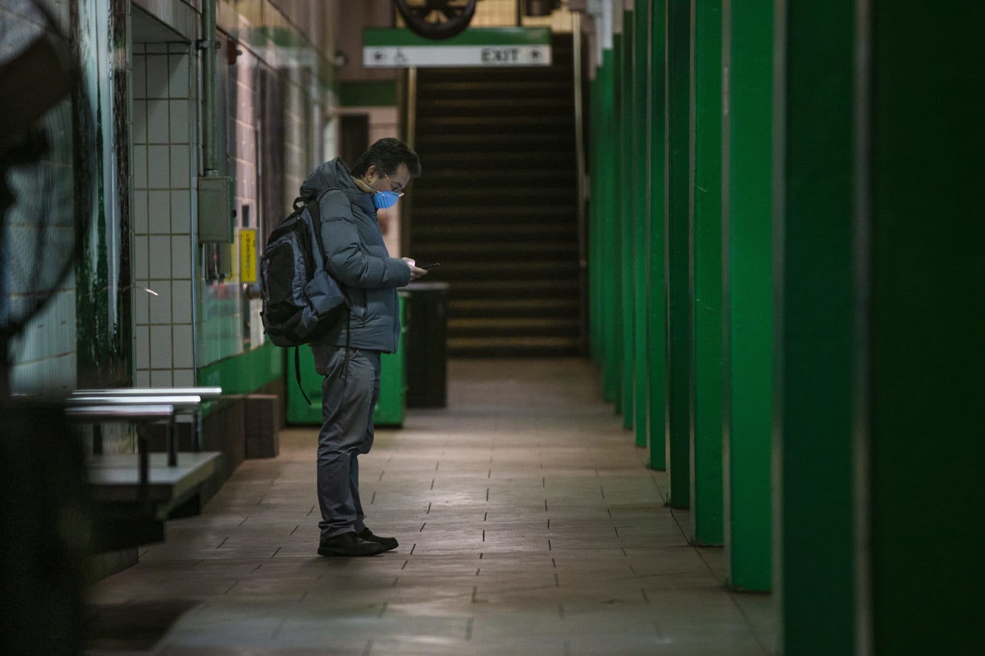 A man waits for a train in the Arlington MBTA station. (Jesse Costa/WBUR)