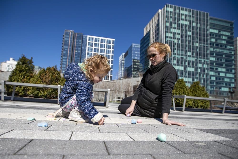 Two-year-old Thayer Elia and her mother Alaska draw with chalk on the ground at the Seaport Common. (Jesse Costa/WBUR)