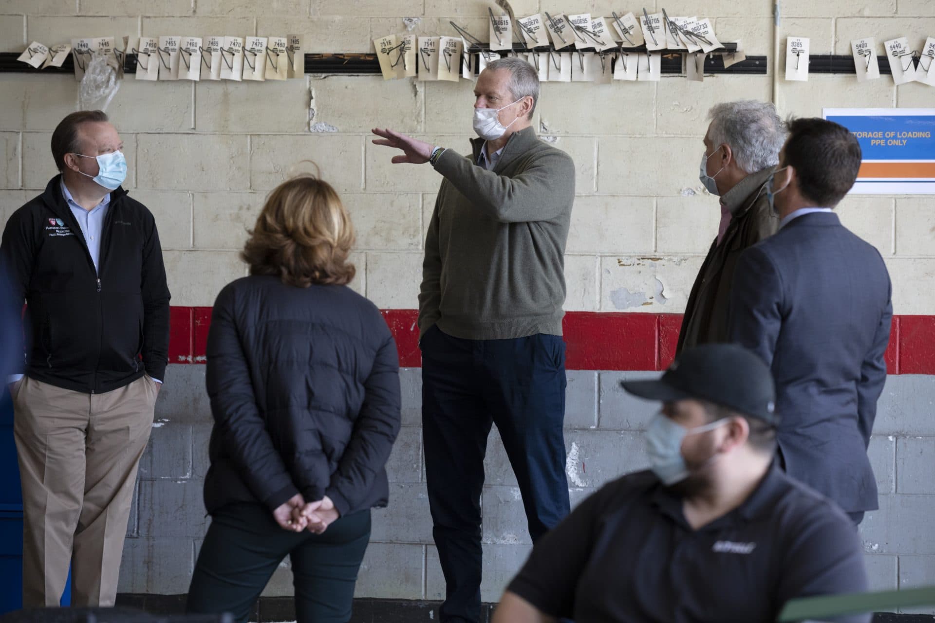 Massachusetts Gov. Charlie Baker (center) wears a protective mask while visiting the Battelle N95 decontamination site, on Saturday, April 11, in Somerville, Mass. (Michael Dwyer/AP)
