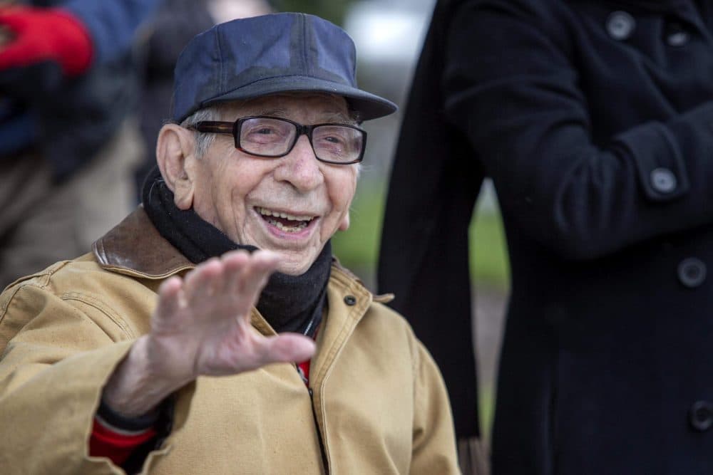 100-year-old Joe Markarian waves as a parade of well-wishers in cars drive by on Galen Street. (Robin Lubbock/WBUR)