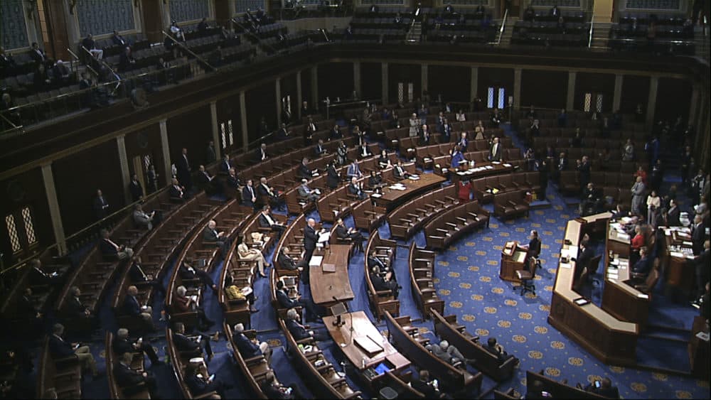 Members of the House practice social distancing as they sit on the floor and in the public gallery above during debate on the coronavirus stimulus package on March 27. (House Television via AP)