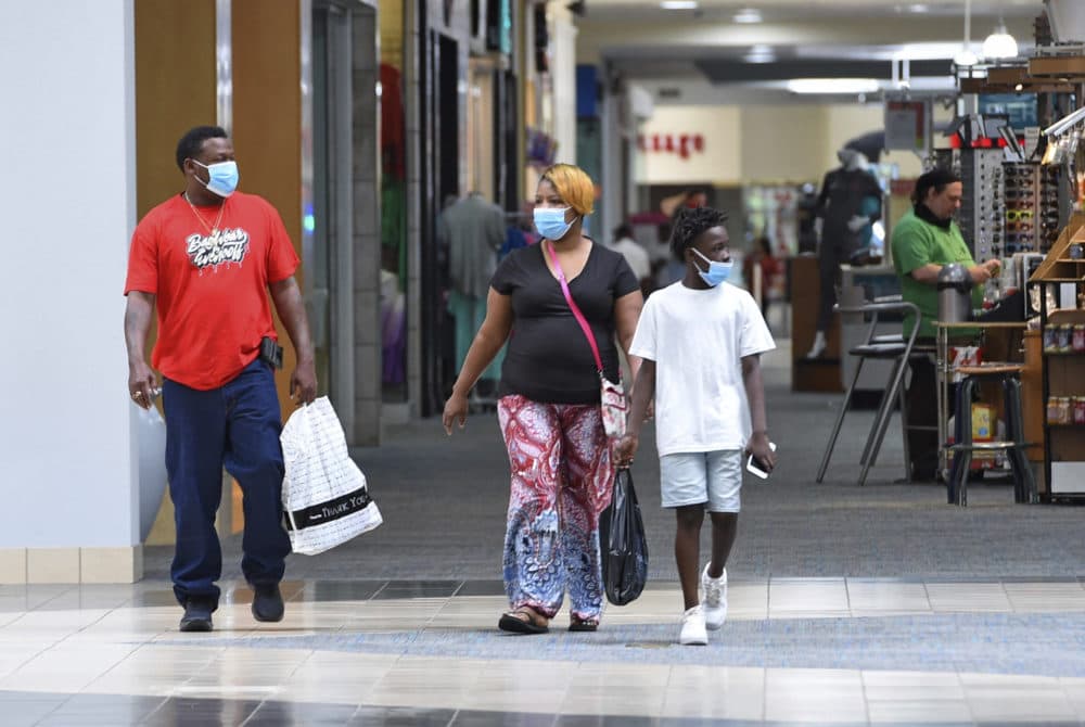Ronnie Johnson, left, Gwen Evans, center, and Jamarion Davis shop while wearing masks to protect against coronavirus,  after the Anderson Mall opened to limited business, Friday, April 24 2020 in Anderson, S.C. (Richard Shiro/AP Photo)
