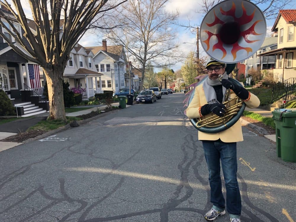 Zack Hickman plays his sousaphone on the streets of Watertown. (Bruce Gellerman/WBUR)