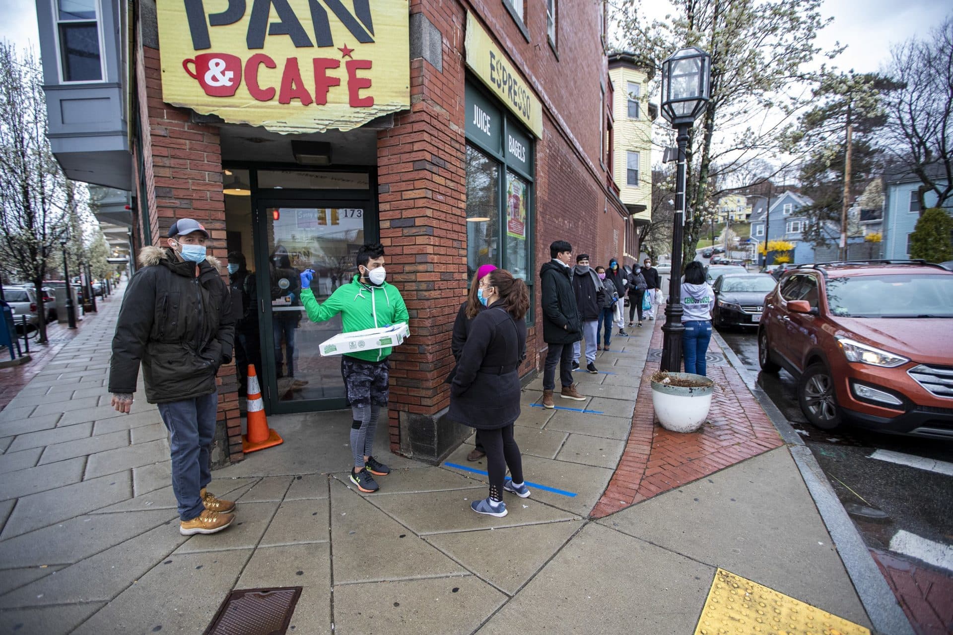 Una fila de residentes de Chelsea se extiende hasta Forsyth Street para ordenar la comida que está distribuyendo Chelsea Collaborative. (Jesse Costa/WBUR)