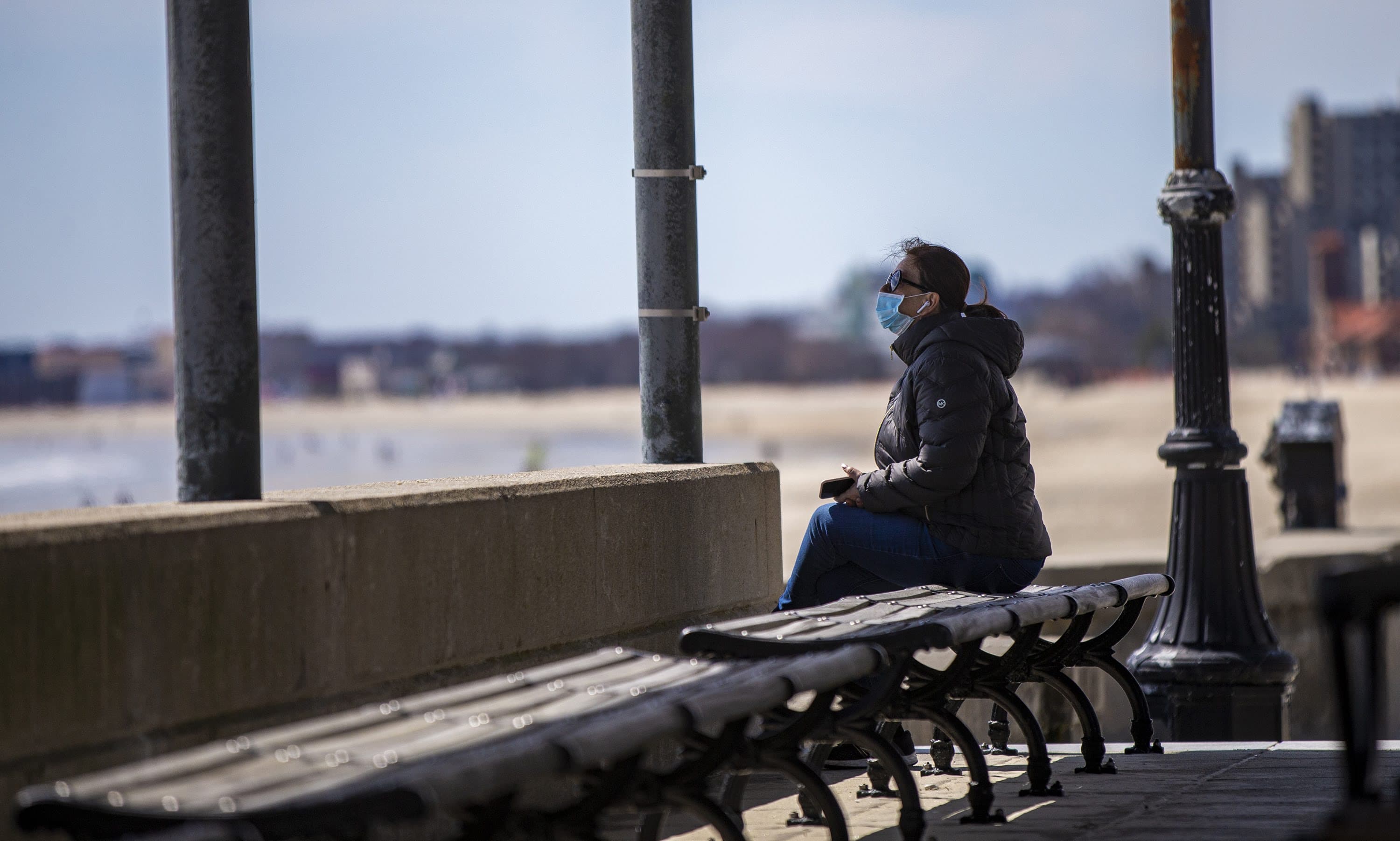 A woman sits alone in an empty pavilion at Revere Beach. (Jesse Costa/WBUR)