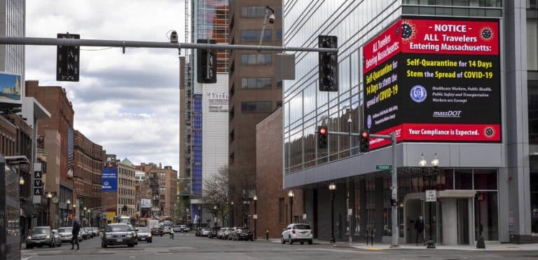 A sign on Tremont Street urges travelers to Boston to quarantine for 14 days. (Robin Lubbock/WBUR)