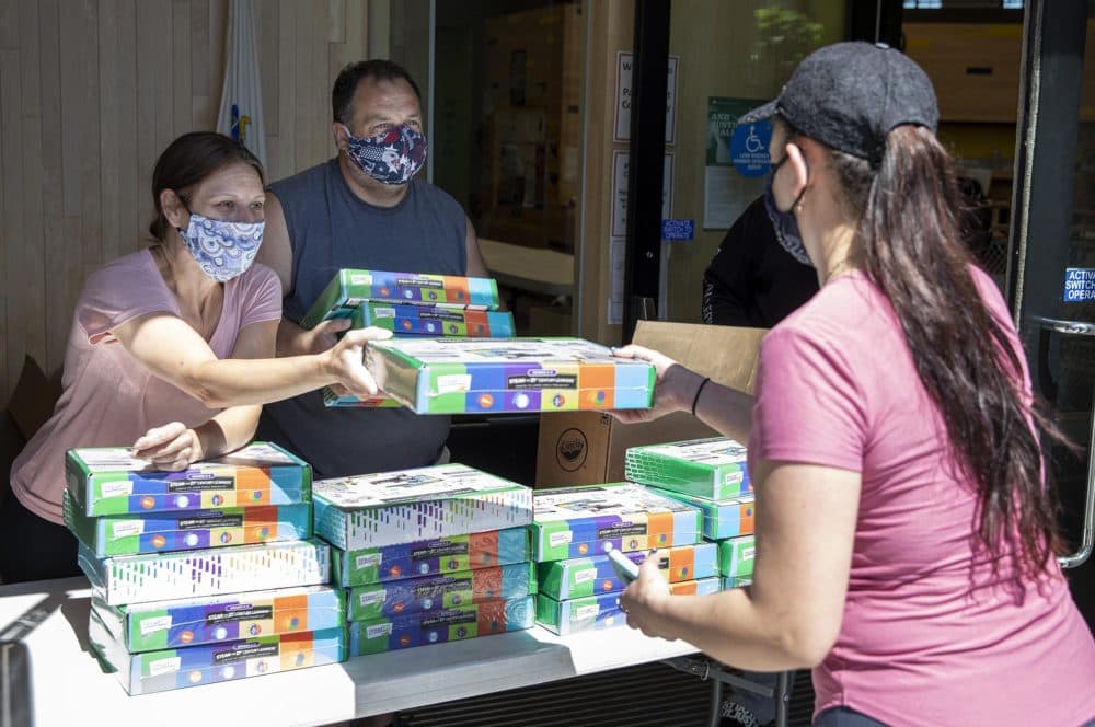 Nicole DaSilva and Bobby DeDominicis hand out Crayola art kits at the Boston Centers for Youth & Families center on Paris Street in East Boston, to families with children in kindergarten up to fifth grade. (Robin Lubbock/WBUR)