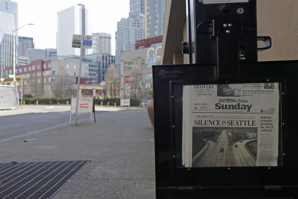 The street next to a Seattle Times newspaper box in front of the building that houses the Times' newsroom is empty, Sunday, March 15, 2020 in Seattle, as the headline "Silence in Seattle" is displayed. (Ted S. Warren/AP Photo)