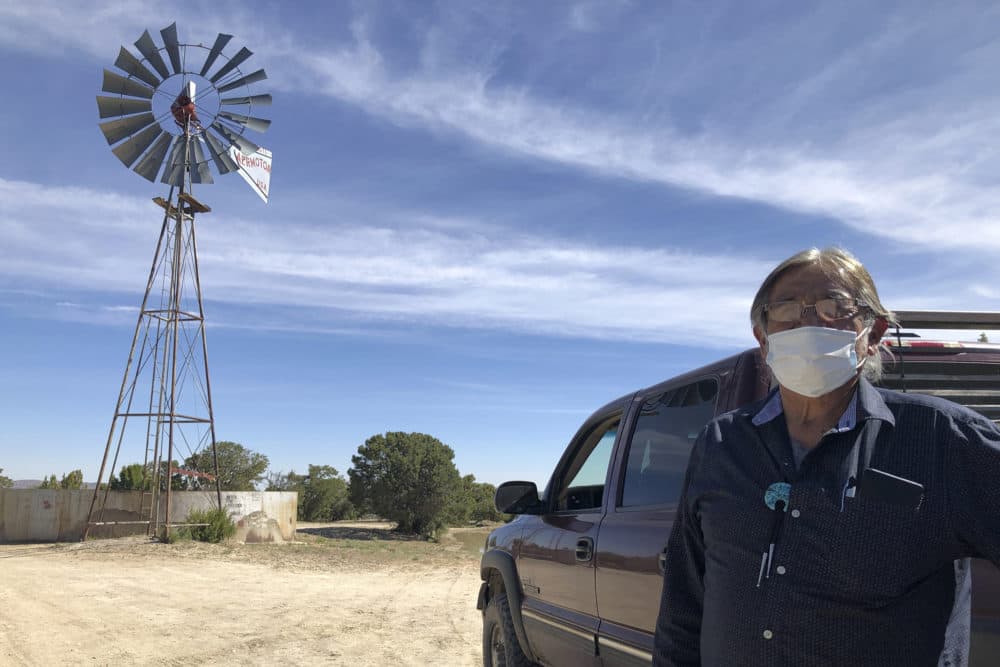 Johnnie Henry, president of the Navajo Nation's Church Rock chapter house community center, hauls drinking water to neighbors in Gallup, N.M., Thursday, May 7, 2020. Henry says that a lockdown at Gallup in response to the spread of the coronavirus came as a suprise to many Navajo Nation residents who depend on Gallup for supplies they can't access. (AP Photo/Morgan Lee)
