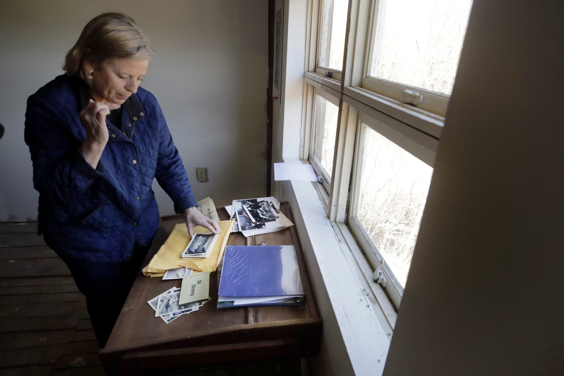 Emily DiPalma Aho looks over photographs and memorabilia of her father. (Charles Krupa/AP)