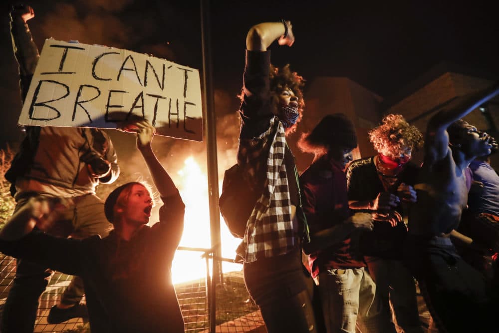 Protestors demonstrate outside of a burning Minneapolis 3rd Police Precinct, Thursday, May 28, 2020, in Minneapolis. Protests over the death of George Floyd, a black man who died in police custody Monday, broke out in Minneapolis for a third straight night. (John Minchillo/AP)