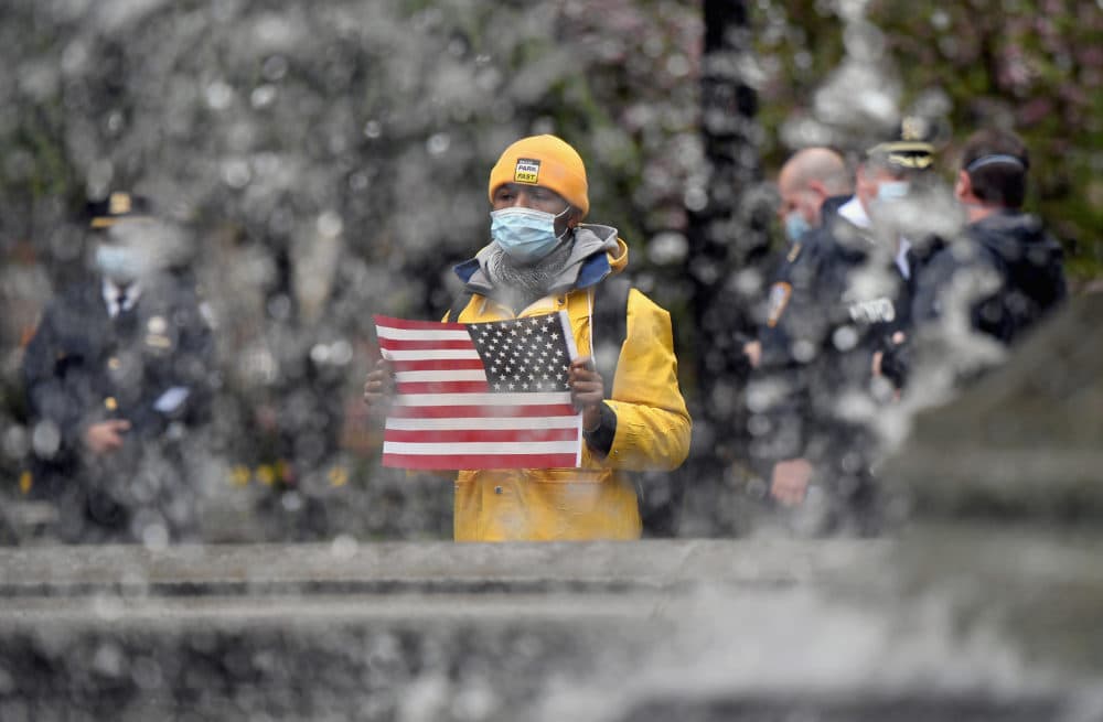 A demonstrator wearing a face mask holds a US flag during a MAGA May Day rally in New York City, on May 1, 2020. (ANGELA WEISS/AFP via Getty Images)