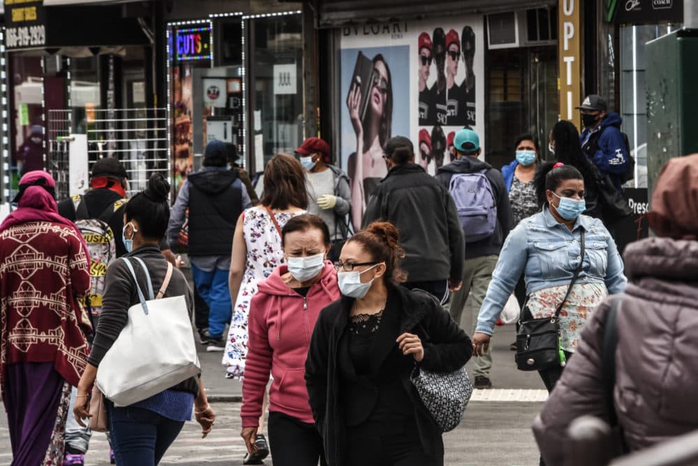People cross the street on May 19, 2020 in the Jamaica neighborhood in the Queens borough in New York City. (Stephanie Keith/Getty Images)