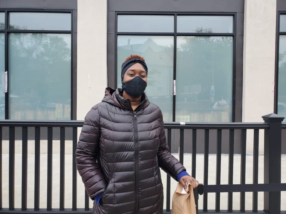 Tayah Peterson-El picks up a bag of cannabis from a newly reopened cannabis store. The store is able to open for the first time since the coronavirus shutdown for curbside pick up. (WBUR/Angus Chen)