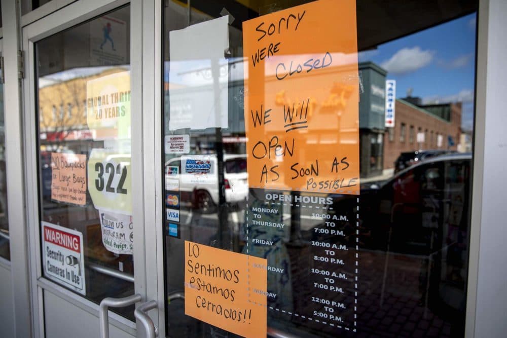 A sign on the closed Thrift Store on Moody Street, Waltham, says it will be open "as soon as possible." (Robin Lubbock/WBUR)