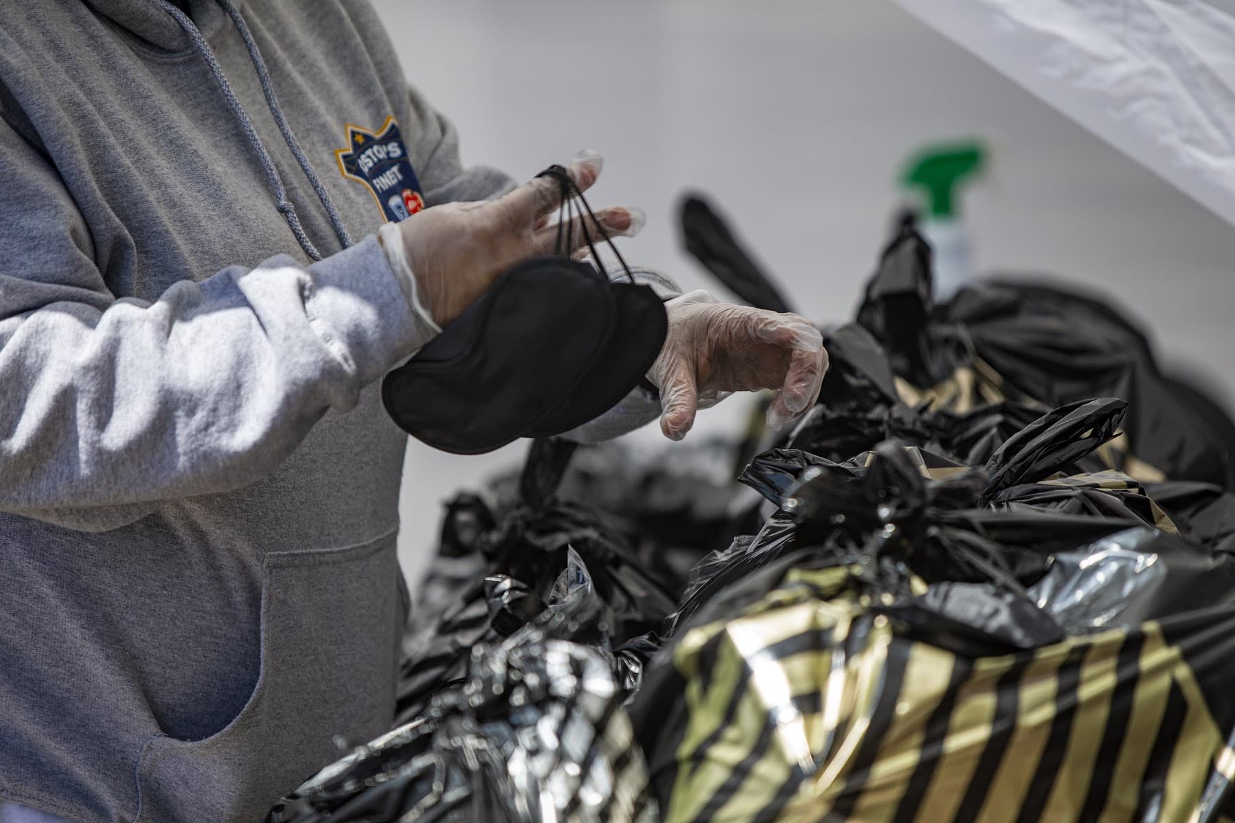 A Rosie's Place employee attaches face masks to the outside of grocery bags women will pick up at the food pantry. (Jesse Costa/WBUR)