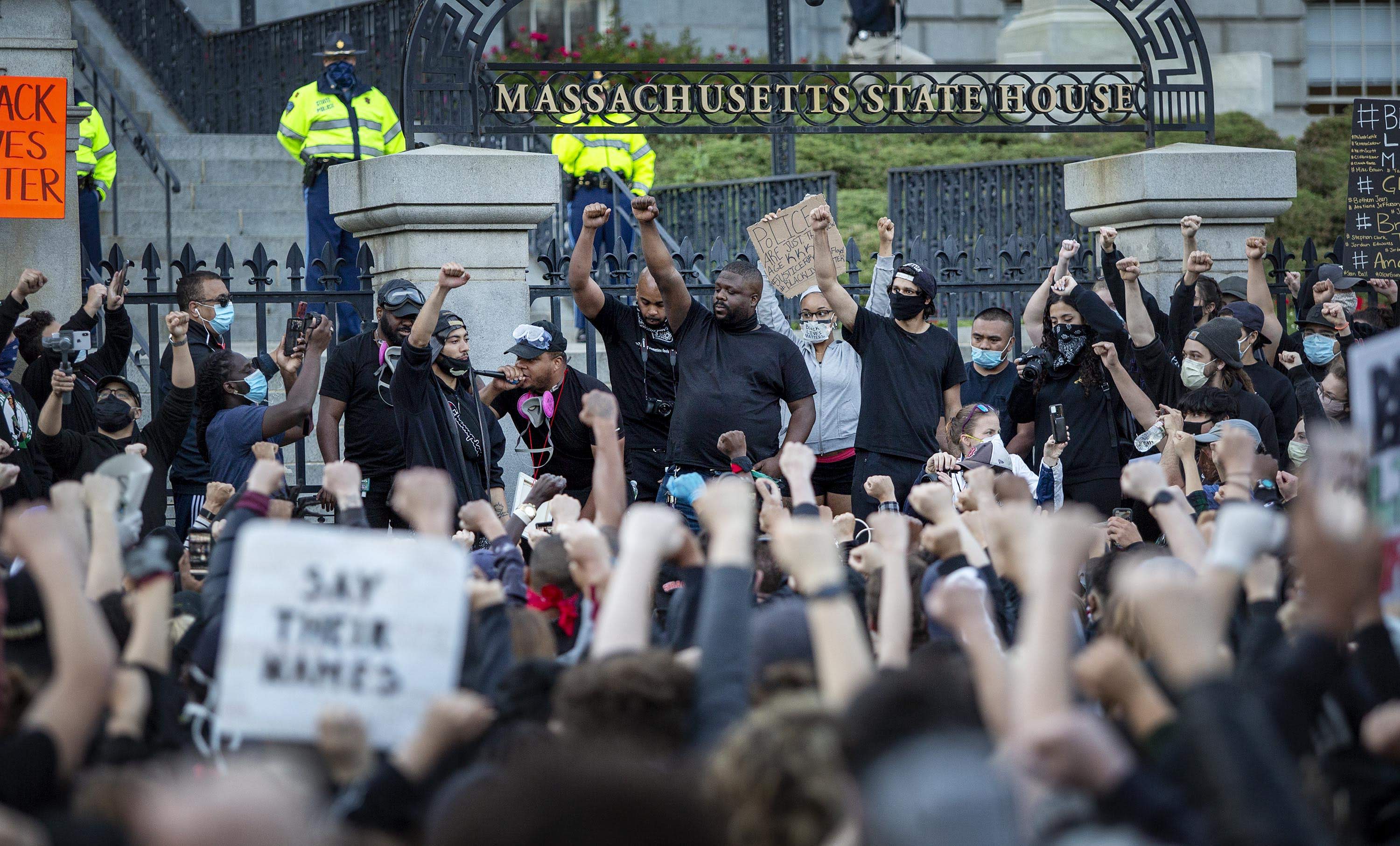 Protesters hold up their fists outside the State House on June 1, 2020. (Robin Lubbock/WBUR)