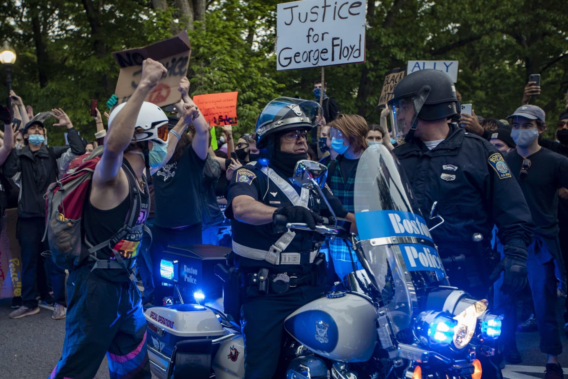 A man screams at police officers surrounded by protesters on Circuit Road. (Jesse Costa/WBUR)
